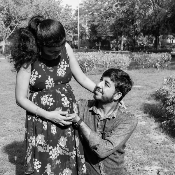 乳児撮影のためにポーズをとるインドのカップル 二人は緑の草の芝生の上でポーズをとっている女性はインドのニューデリーにあるロディ ガーデンで赤ん坊のバンプを落下させている — ストック写真
