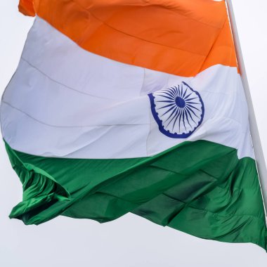 India flag flying high at Connaught Place with pride in blue sky, India flag fluttering, Indian Flag on Independence Day and Republic Day of India, tilt up shot, Waving Indian flag, Har Ghar Tiranga