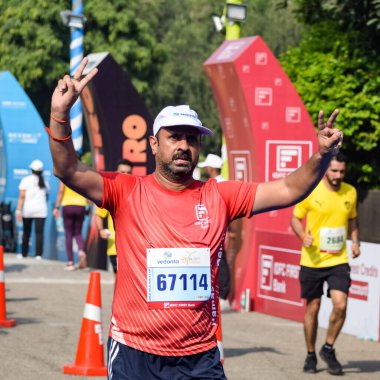 Yeni Delhi, Hindistan - 16 Ekim 2022 - Bitmek üzere olan maraton katılımcılarının bitiş çizgisini geçmek üzere olan Delhi Yarı Maratonu 2022