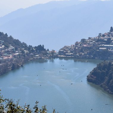 Akşam vakti Nainital, Uttarakhand, Hindistan 'daki Mall Yolu' nun yanındaki Naini Gölü 'nün manzarası dağlarla ve mavi gökyüzüyle güzel Nainital Gölü manzarası.