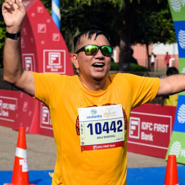 Yeni Delhi, Hindistan - 16 Ekim 2022 - Bitmek üzere olan maraton katılımcılarının bitiş çizgisini geçmek üzere olan Delhi Yarı Maratonu 2022
