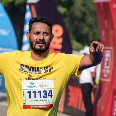 Yeni Delhi, Hindistan - 16 Ekim 2022 - Bitmek üzere olan maraton katılımcılarının bitiş çizgisini geçmek üzere olan Delhi Yarı Maratonu 2022