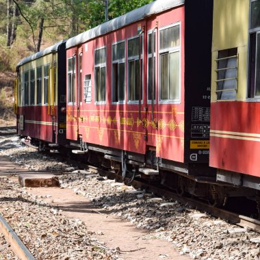 Oyuncak tren dağ yamaçlarında hareket ediyor, güzel bir manzara, bir dağ yamacı, bir vadi yamaçtan tepeye hareket ediyor, yeşil doğal ormanın arasında. Hindistan 'da Kalka' dan Shimla 'ya giden oyuncak tren, Hint treni.