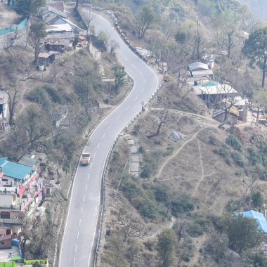 Nainital, Uttarakhand, Hindistan 'daki dağlarda giden trafik araçlarının hava görüntüsü, trafik araçlarının hareketi için dağın tepesinden görüntü.
