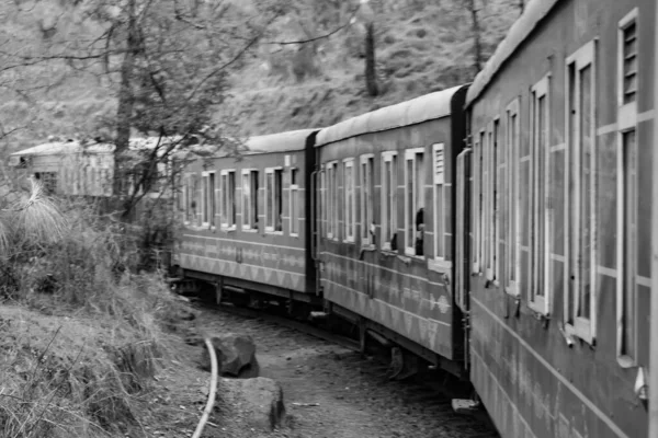 Toy Train moving on mountain slope, beautiful view, one side mountain, one side valley moving on railway to the hill, among green natural forest.Toy train from Kalka to Shimla in India-Black and White