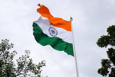 India flag flying high at Connaught Place with pride in blue sky, India flag fluttering, Indian Flag on Independence Day and Republic Day of India, tilt up shot, Waving Indian flag, Har Ghar Tiranga
