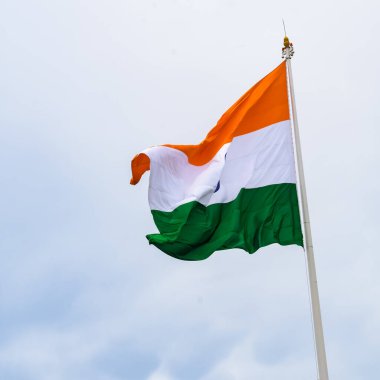 India flag flying high at Connaught Place with pride in blue sky, India flag fluttering, Indian Flag on Independence Day and Republic Day of India, tilt up shot, Waving Indian flag, Har Ghar Tiranga