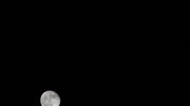 Moon Timelapse, Stock zamanaşımı: Dolunay karanlık gökyüzünde yükseliyor, gece vakti. Dolunay zamanı, gece karanlığında karanlık gökyüzünde ay ışığıyla birlikte kaybolur. Yüksek kaliteli beleş video kaydı veya zaman ayarlı