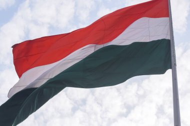 India flag flying high at Connaught Place with pride in blue sky, India flag fluttering, Indian Flag on Independence Day and Republic Day of India, tilt up shot, Waving Indian flag, Har Ghar Tiranga