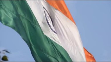 India flag flying high at Connaught Place with pride in blue sky, India flag fluttering, Indian Flag on Independence Day and Republic Day of India, tilt up shot, Waving Indian flag, Har Ghar Tiranga