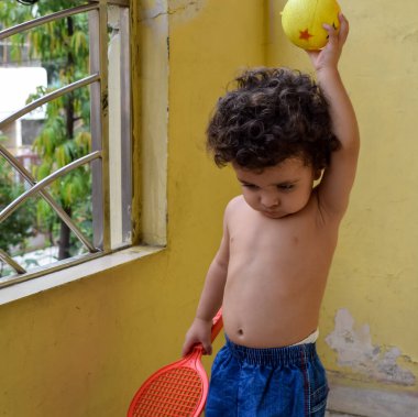 Şirin küçük çocuk Shivaay Sapra yaz zamanı evde balkonda, tatlı küçük çocuk gün ışığında fotoşop, küçük çocuk fotoğraf çekimi sırasında evde eğleniyor.