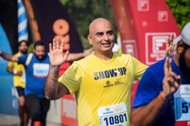 Yeni Delhi, Hindistan - 16 Ekim 2022 - Bitmek üzere olan maraton katılımcılarının bitiş çizgisini geçmek üzere olan Delhi Yarı Maratonu 2022