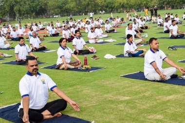 Yeni Delhi, Hindistan, 21 Haziran 2022 - Uluslararası Yoga Günü 'nde Delhi' deki Yamuna Spor Kompleksi 'nde grup Yoga egzersiz oturumu, kriket stadyumunda yoga derslerine katılan büyük bir grup yetişkin