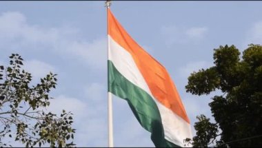 India flag flying high at Connaught Place with pride in blue sky, India flag fluttering, Indian Flag on Independence Day and Republic Day of India, tilt up shot, Waving Indian flag, Har Ghar Tiranga