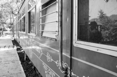 Oyuncak tren dağ yamaçlarında hareket ediyor, güzel bir manzara, bir dağ yamacı, bir vadi yamaçtan tepeye hareket ediyor, yeşil doğal ormanın arasında. Hindistan 'da Kalka' dan Shimla 'ya giden oyuncak tren, Hint treni.