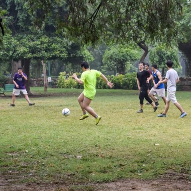 Yeni Delhi, Hindistan - 01 Temmuz 2018: Kötü bir futbol sahasında bölgesel Derby şampiyonasında yerel futbol takımının futbolcuları. Stadyumun çimen yeşili sahasında sıcak bir futbol maçı var.