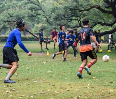 Yeni Delhi, Hindistan - 01 Temmuz 2018: Kötü bir futbol sahasında bölgesel Derby şampiyonasında yerel futbol takımının futbolcuları. Stadyumun çimen yeşili sahasında sıcak bir futbol maçı var.