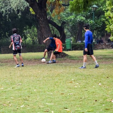 Yeni Delhi, Hindistan - 01 Temmuz 2018: Kötü bir futbol sahasında bölgesel Derby şampiyonasında yerel futbol takımının futbolcuları. Stadyumun çimen yeşili sahasında sıcak bir futbol maçı var.