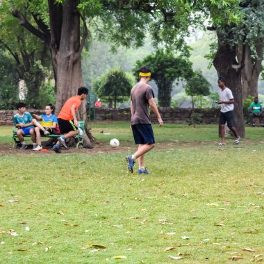 Yeni Delhi, Hindistan - 01 Temmuz 2018: Kötü bir futbol sahasında bölgesel Derby şampiyonasında yerel futbol takımının futbolcuları. Stadyumun çimen yeşili sahasında sıcak bir futbol maçı var.