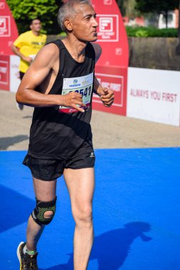 Yeni Delhi, Hindistan - 16 Ekim 2022 - Bitmek üzere olan maraton katılımcılarının bitiş çizgisini geçmek üzere olan Delhi Yarı Maratonu 2022