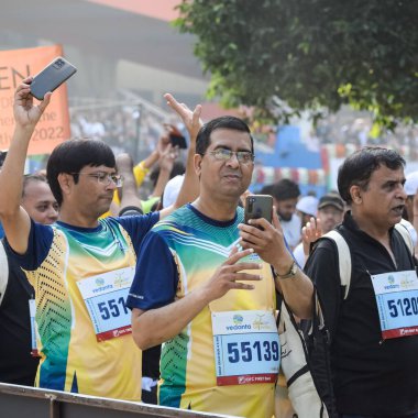 Yeni Delhi, Hindistan - 16 Ekim 2022 - Bitmek üzere olan maraton katılımcılarının bitiş çizgisini geçmek üzere olan Delhi Yarı Maratonu 2022