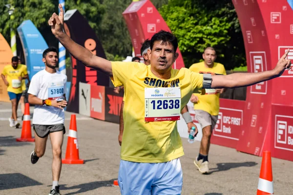 Yeni Delhi, Hindistan - 16 Ekim 2022 - Bitmek üzere olan maraton katılımcılarının bitiş çizgisini geçmek üzere olan Delhi Yarı Maratonu 2022