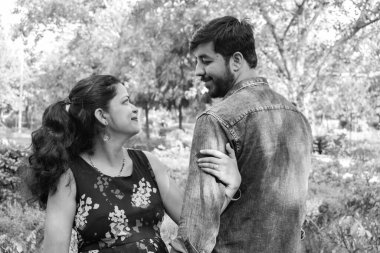 Hintli çift hamilelik çekimleri için poz veriyor. Çift yeşil çimenli bir çimenlikte poz veriyor ve kadın Hindistan, Yeni Delhi 'deki Lodhi Garden' da bebek çarpması yaşıyor.