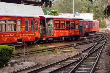 View of Toy train coach from the middle of railway track during daytime near Kalka railway station in India, Toy train coach view, Indian Railway junction, Heavy industry