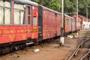 View of Toy train coach from the middle of railway track during daytime near Kalka railway station in India, Toy train coach view, Indian Railway junction, Heavy industry