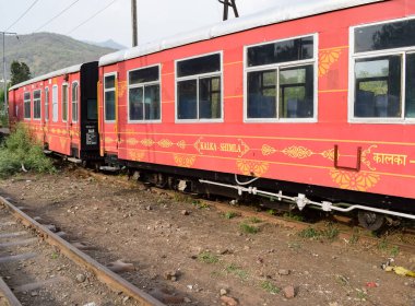 View of Toy train coach from the middle of railway track during daytime near Kalka railway station in India, Toy train coach view, Indian Railway junction, Heavy industry