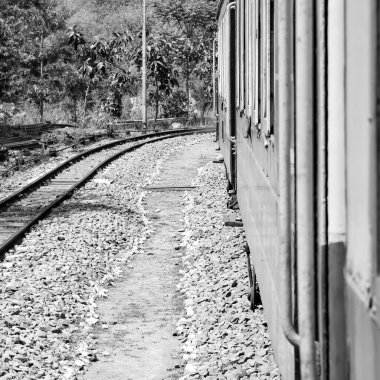 Toy Train moving on mountain slope, beautiful view, one side mountain, one side valley moving on railway to the hill, among green natural forest. Toy train from Kalka to Shimla in India-Black and White