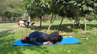 Young Indian woman practicing yoga outdoor in a park. Beautiful girl practice basic yoga pose. Calmness and relax, female happiness. Basic Yoga poses outdoor 