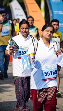 Yeni Delhi, Hindistan - 16 Ekim 2022 - Bitmek üzere olan maraton katılımcılarının bitiş çizgisini geçmek üzere olan Delhi Yarı Maratonu 2022