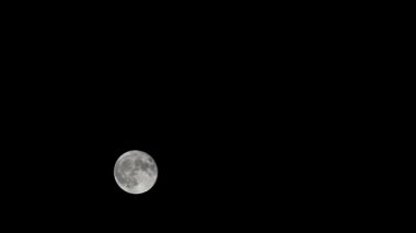 Moon Timelapse, Stock zamanaşımı: Dolunay karanlık gökyüzünde yükseliyor, gece vakti. Dolunay zamanı, gece karanlığında karanlık gökyüzünde ay ışığıyla birlikte kaybolur. Yüksek kaliteli beleş video kaydı veya zaman ayarlı