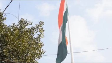 India flag flying high at Connaught Place with pride in blue sky, India flag fluttering, Indian Flag on Independence Day and Republic Day of India, tilt up shot, Waving Indian flag, Har Ghar Tiranga