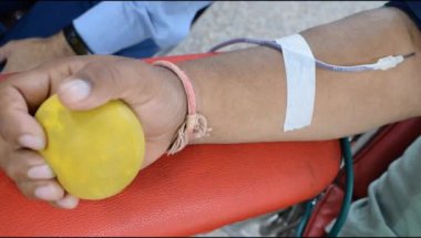 Blood donor at Blood donation camp held with a bouncy ball holding in hand at Balaji Temple, Vivek Vihar, Delhi, India, Image for World blood donor day on June 14 every year, Blood Donation Camp