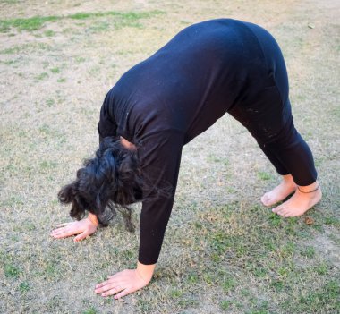 Young Indian woman practicing yoga outdoor in a park. Beautiful girl practice basic yoga pose. Calmness and relax, female happiness. Basic Yoga poses outdoor