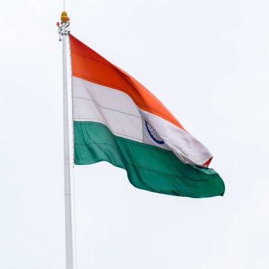 India flag flying high at Connaught Place with pride in blue sky, India flag fluttering, Indian Flag on Independence Day and Republic Day of India, tilt up shot, Waving Indian flag, Har Ghar Tiranga