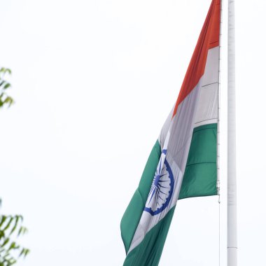 India flag flying high at Connaught Place with pride in blue sky, India flag fluttering, Indian Flag on Independence Day and Republic Day of India, tilt up shot, Waving Indian flag, Har Ghar Tiranga