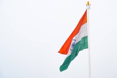 India flag flying high at Connaught Place with pride in blue sky, India flag fluttering, Indian Flag on Independence Day and Republic Day of India, tilt up shot, Waving Indian flag, Har Ghar Tiranga