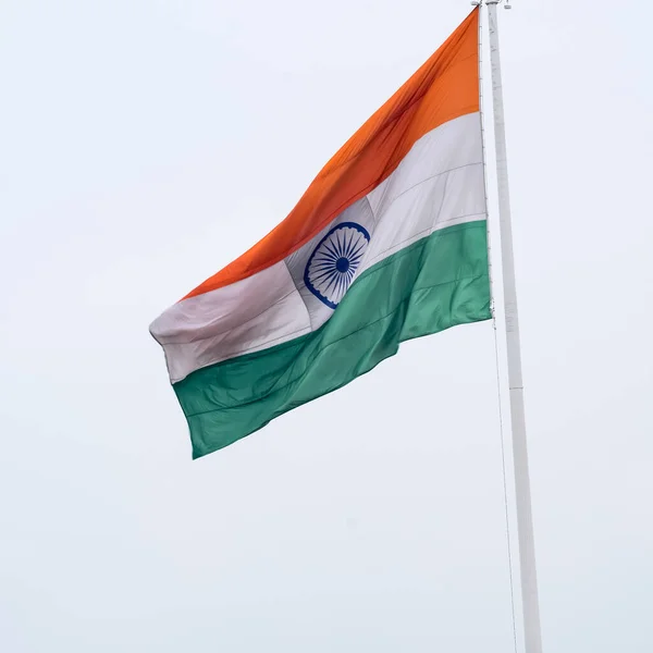 stock image India flag flying high at Connaught Place with pride in blue sky, India flag fluttering, Indian Flag on Independence Day and Republic Day of India, tilt up shot, Waving Indian flag, Har Ghar Tiranga