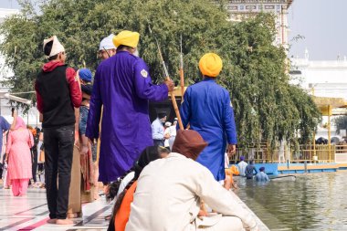 Amritsar, Punjab, Hindistan 'daki Altın Tapınak' ın (Harmandir Sahib) çeşitli yerlerinden kimliği belirsiz dindarlar, Hindistan 'ın Amritsar kentindeki Sihlerin ana tapınağı olan ünlü Hint sih simgesi, Altın Tapınak