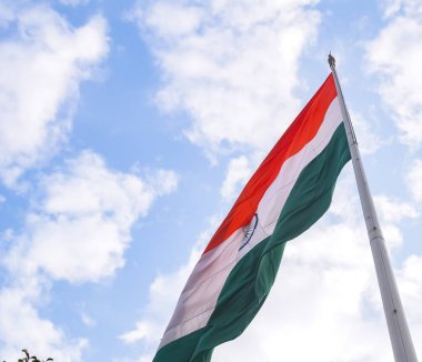 India flag flying high at Connaught Place with pride in blue sky, India flag fluttering, Indian Flag on Independence Day and Republic Day of India, tilt up shot, Waving Indian flag, Har Ghar Tiranga