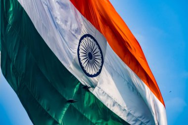 India flag flying high at Connaught Place with pride in blue sky, India flag fluttering, Indian Flag on Independence Day and Republic Day of India, tilt up shot, Waving Indian flag, Har Ghar Tiranga