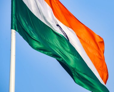India flag flying high at Connaught Place with pride in blue sky, India flag fluttering, Indian Flag on Independence Day and Republic Day of India, tilt up shot, Waving Indian flag, Har Ghar Tiranga