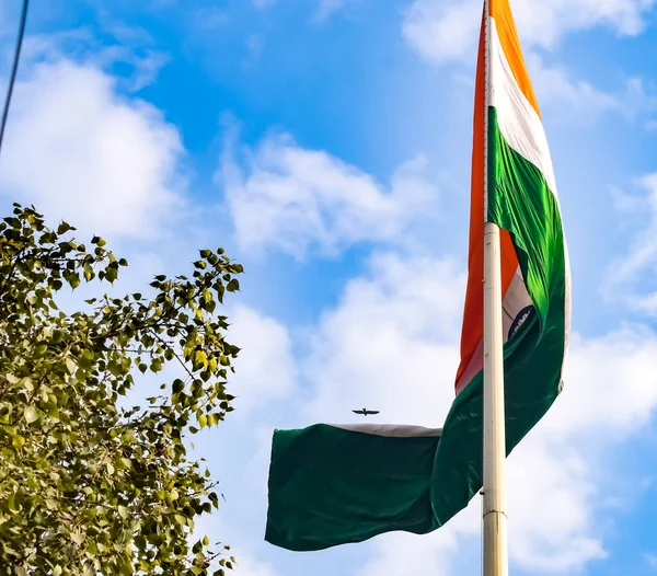 stock image India flag flying high at Connaught Place with pride in blue sky, India flag fluttering, Indian Flag on Independence Day and Republic Day of India, tilt up shot, Waving Indian flag, Har Ghar Tiranga