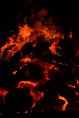 Siyah arka planda alevler, alev alev dokusu arka planda, çok güzel, ateş yanıyor, ateş odun ve inek gübresi ateşiyle yanıyor.