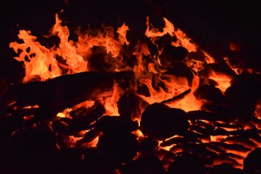 Siyah arka planda alevler, alev alev dokusu arka planda, çok güzel, ateş yanıyor, ateş odun ve inek gübresi ateşiyle yanıyor.