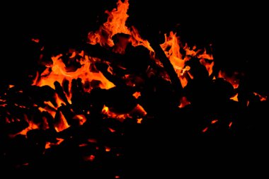 Siyah arka planda alevler, alev alev dokusu arka planda, çok güzel, ateş yanıyor, ateş odun ve inek gübresi ateşiyle yanıyor.