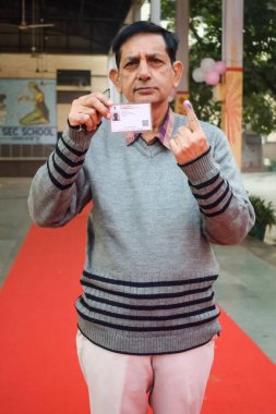 New Delhi, India - December 04 2022 - Unidentified people showing their ink-marked fingers after casting votes in front of polling booth of east Delhi area for MCD local body Elections 2022